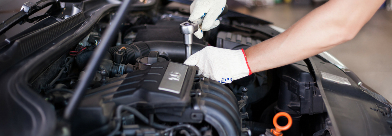 Mechanic using socket wrench on engine parts
