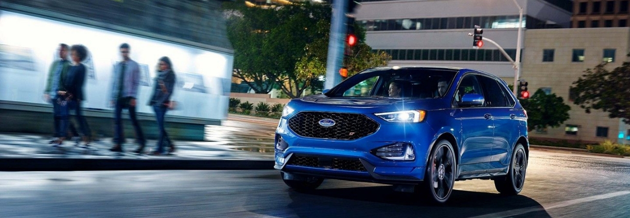 Blue 2019 Ford Edge rounding street corner.